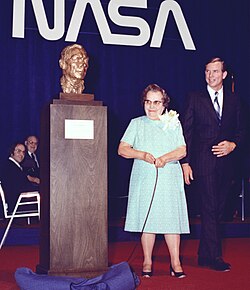 Dryden's wife next to a bust of Dryden, Scott by her side