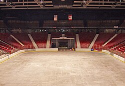 An empty arena with the sheet of ice and the score board