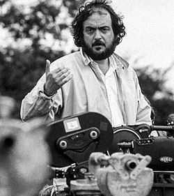 A black and white photograph of Kubrick above a camera while filming Barry Lyndon in 1975