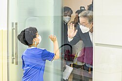 Lee Jae-myung visiting a child care center and waving at a child