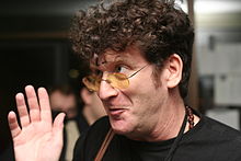 Portrait of a man in glasses with brown curly hair looking to the left