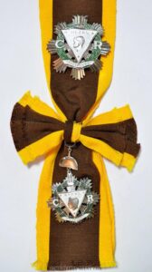 Regalia of a KGOR includes a silver breast star and sash of the Order