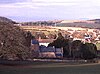 Buildings nestled in rolling hills.