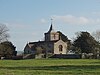 Stone building with square tower topped by a small spires.