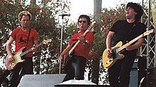 Three men on a stage playing instruments