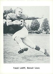 Trading card image of Yale Lary doing the Heisman pose with a ball in one arm and no helmet.