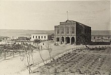 Large building, with wide road and field in front