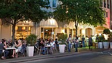 People sitting at tables near a street