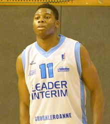 Yabusele in 2013. He is a tall, black man with short hair and no facial hair, wearing a white sports jersey.