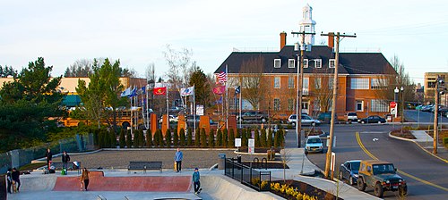 A skate park and plaza in Gresham with a New England-style building in the background