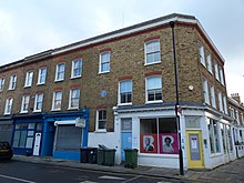 Exterior of two storey brick building with shop space on ground floor