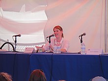 Ringwald seated at a table with a microphone