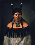Image 14Hinepare of Ngāti Kahungunu, is wearing a traditional korowai cloak adorned with a black fringe border. The two huia feathers in her hair, indicate a chiefly lineage. She also wears a pounamu hei-tiki and earring, as well as a shark tooth (mako) earring. The moko-kauae (chin-tattoo) is often based on one's role in the iwi. (from Culture of New Zealand)