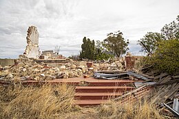 stairs to the verandha, with part of one still standing amongst the rubble