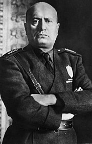 official portrait of Mussolini in uniform with crossed arms