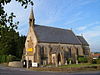 Stone building with arched windows and small turret.