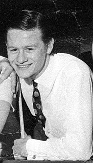 Alex Higgins holding a cue and smiling