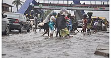 Image of people wading through flooded express way in Lagos.