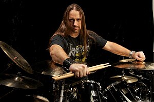 Alfonso Pinzón posing behind a drum kit, looking directly at camera