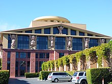 building with part of the columns being held up by statues of the seven dwarfs from Snow White