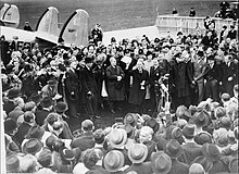 British Prime Minister Neville Chamberlain, landing at Heston aerodrome on 30 September 1938 after his meeting with Hitler at Munich. In his hand he holds the peace agreement between Britain and Germany.