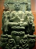 Buddha triad and kneeling Kushan devotee couple. 3rd century.